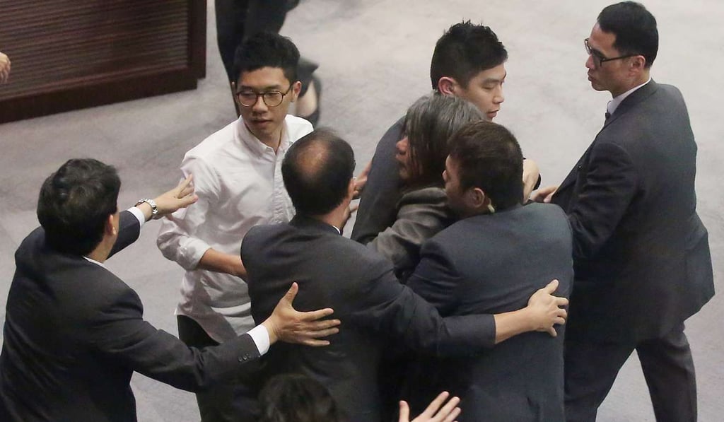 Lawmakers ‘Long Hair’ Leung Kwok-hung and Nathan Law Kwun-chung being surround by security guards during a Finance Committee meeting in Legco on Friday. Photo: Edward Wong