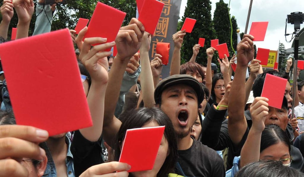 Slogan-chanting demonstrators in Taoyuan hold up red cards asking Zhang Zhijun, the head of the mainland’s Taiwan Affairs Office, to leave Taiwan ahead of a meeting with a senior Taiwanese official in June 2014. Photo: AFP