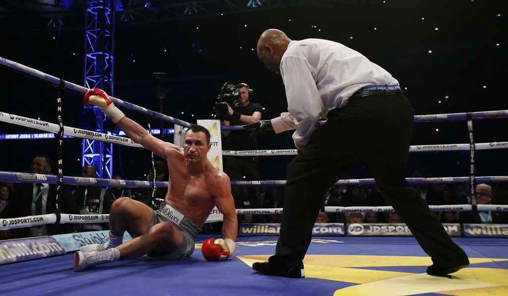 Wladimir Klitschko receives a count by the referee after being knocked down. Photo: Reuters
