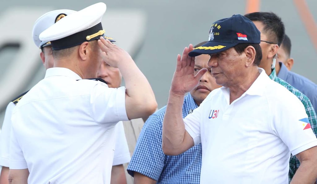 Philippine President Rodrigo Duterte returns the salute of a Chinese Navy officer as he tours a Chinese Naval ship during a visit to Davao city. Photo: Reuters