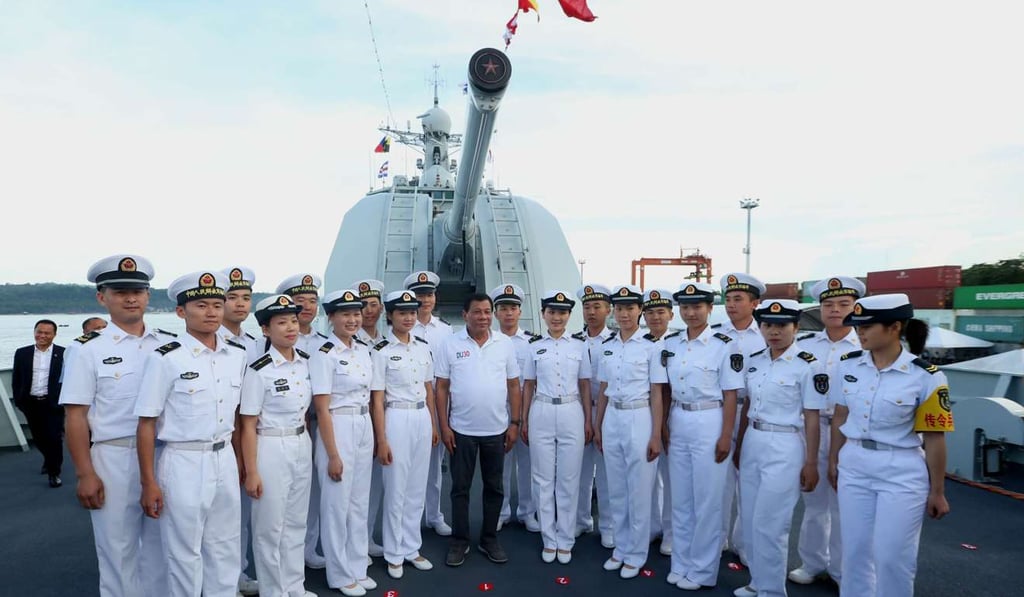 Duterte posing for photos with Chinese sailors while visiting the guided missile frigate Changchun berthed at the Davao international port. Photo: AFP