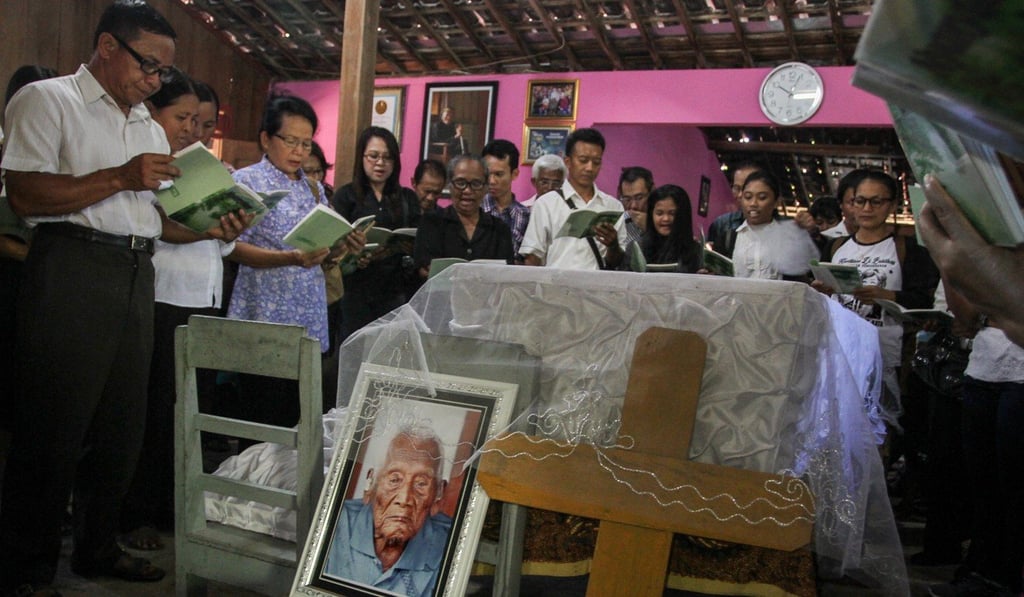 Family and friends pray beside the casket of Sodimejo, who claimed to be the world's oldest person at 146-years-old. Photo: Reuters