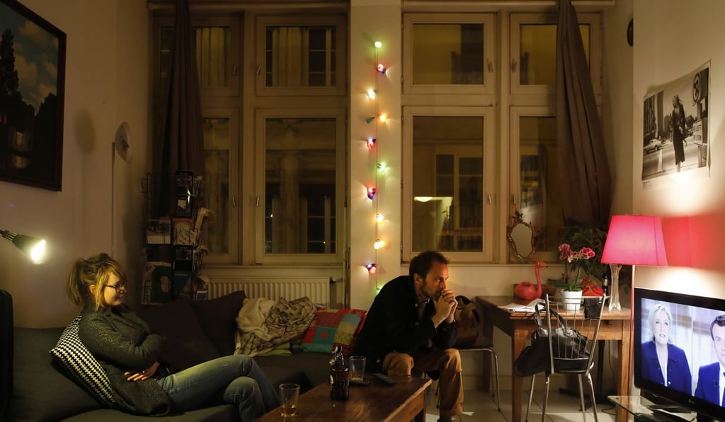 A couple watches a live broadcast television debate pitting French centrist presidential candidate Emmanuel Macron, right, and far-right candidate Marine Le Pen, in Lyon, central France. Photo: AP A couple watches a live broadcast television debate pitting French centrist presidential candidate Emmanuel Macron, right, and far-right candidate Marine Le Pen, in Lyon, central France. Photo: AP