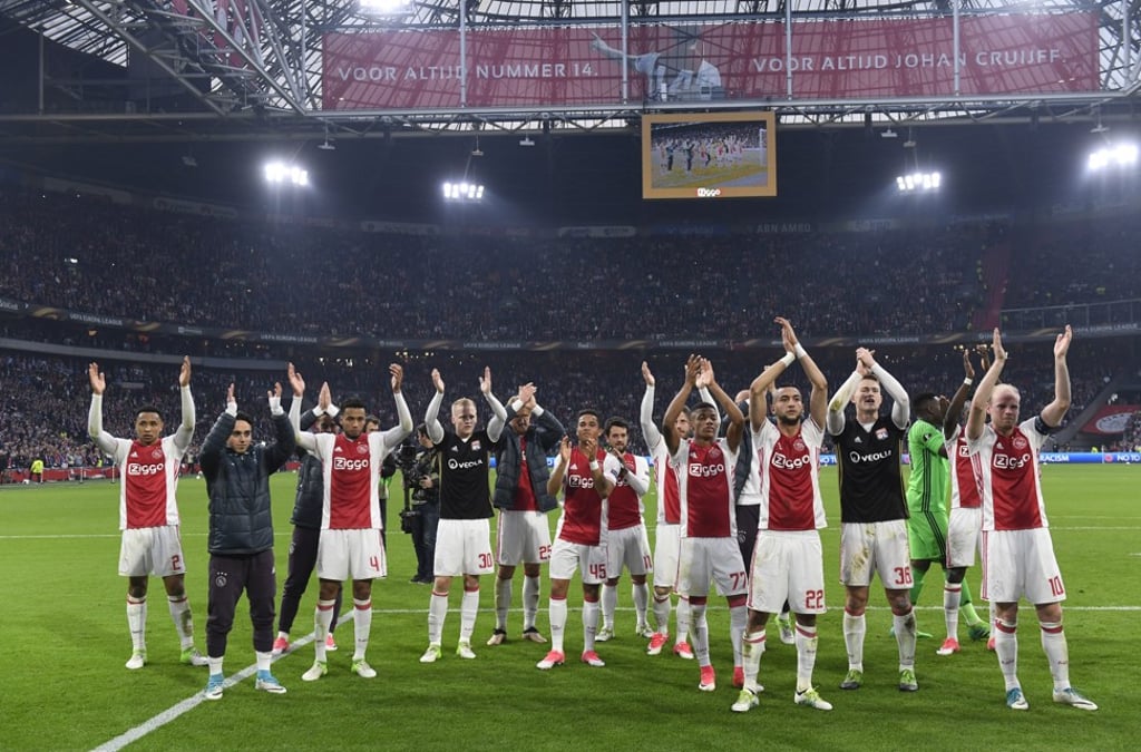 Ajax players celebrate putting one foot in the Europa League final. Photo: Reuters
