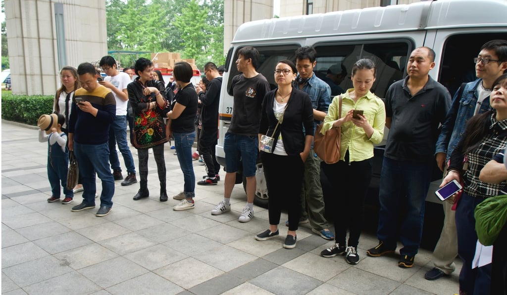 About 40 apartment buyers gathered outside the Beijing Municipal Commission of Housing and Urban-rural Development to demand the government ease a restriction that crippled the value of their assets. Photo: Tom Wang