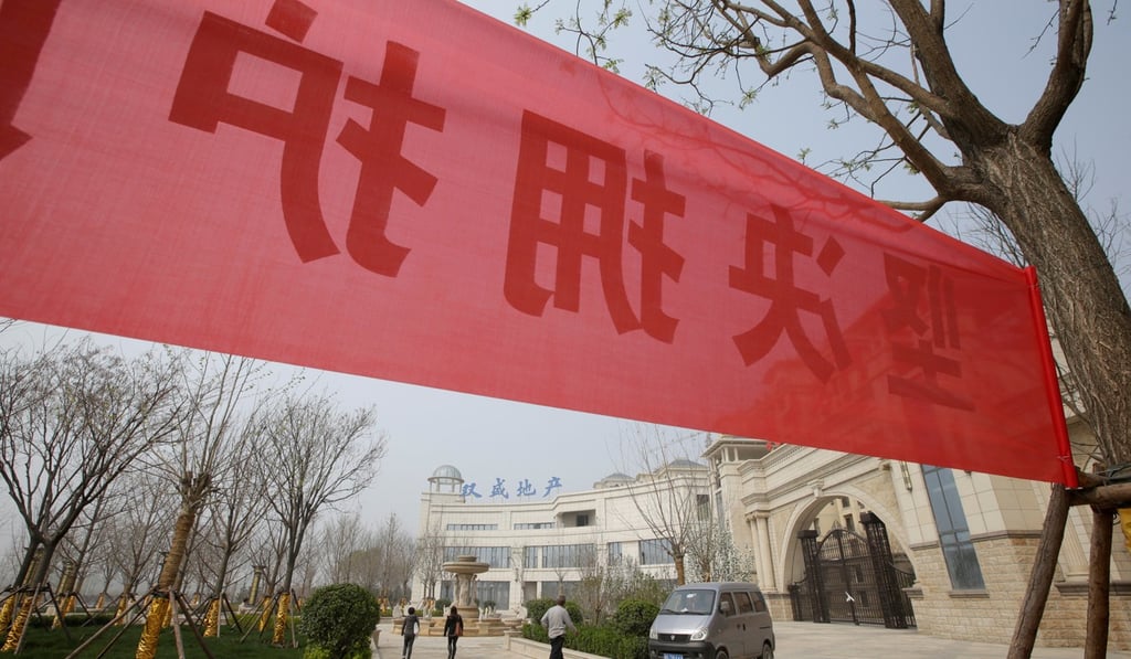 A banner supporting the government’s decision of banning new property sales is placed outside a closed sales office of a property in Xiong county last month. Photo: Reuters