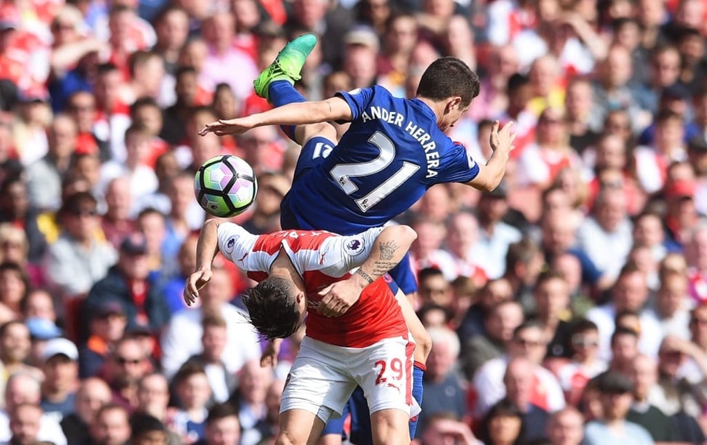 Arsenal’s Granit Xhaka ducks under a challenge from Manchester United’s Ander Herrera. Photo: EPA