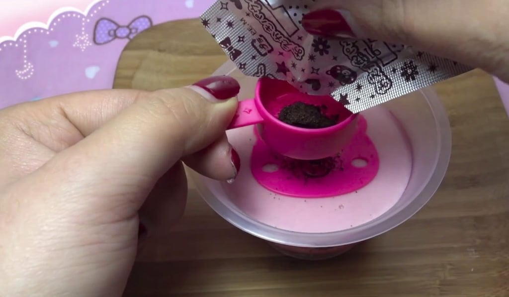 Aimolier opens a tiny sachet to prepare some food.