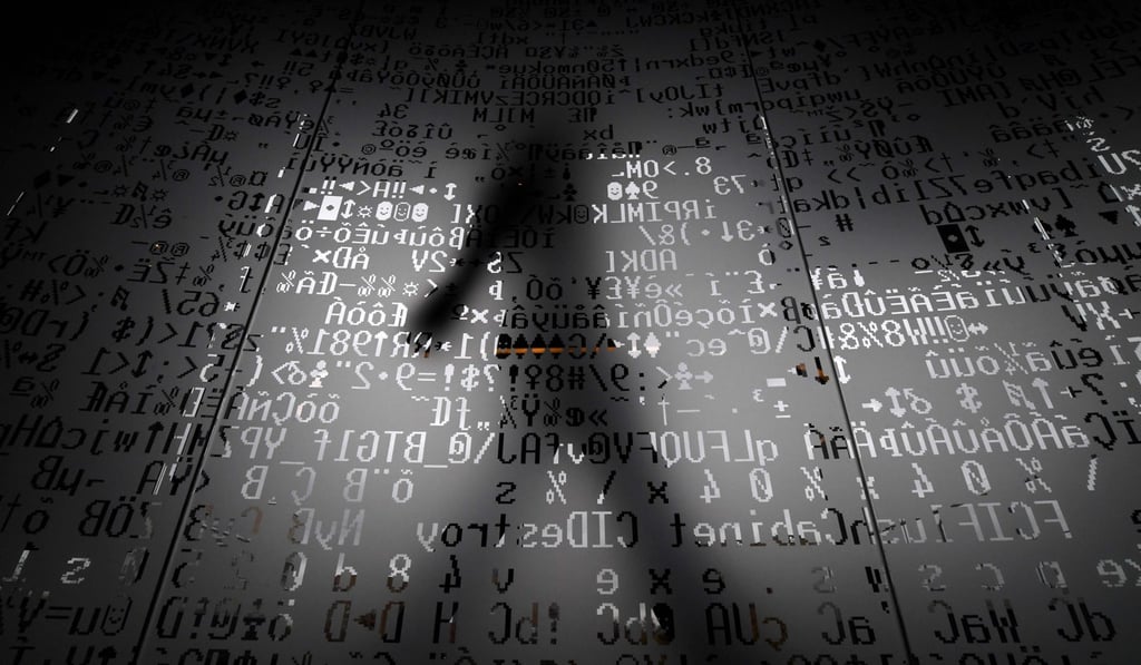 An employee walks behind a glass wall with coding symbols at the headquarters of Internet security giant Kaspersky in Moscow. Photo: AFP
