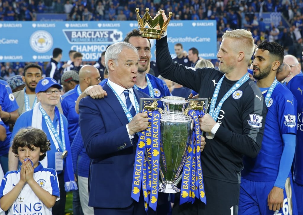 Claudio Ranieri holds the trophy as he celebrates winning the 2015-16 Premier League with Kasper Schmeichel and teammates. Photo: Reuters