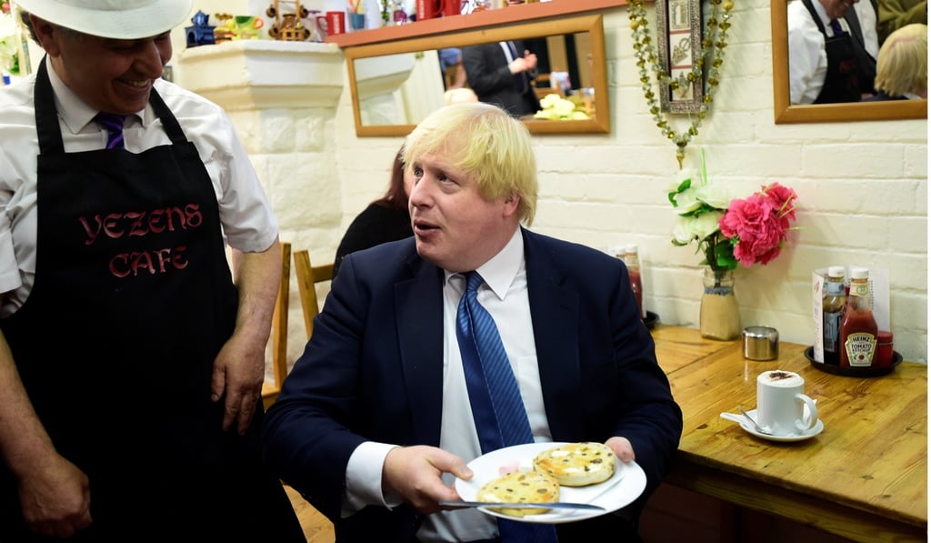Johnson enjoys some food in a cafe in Newport Market. Photo: Reuters