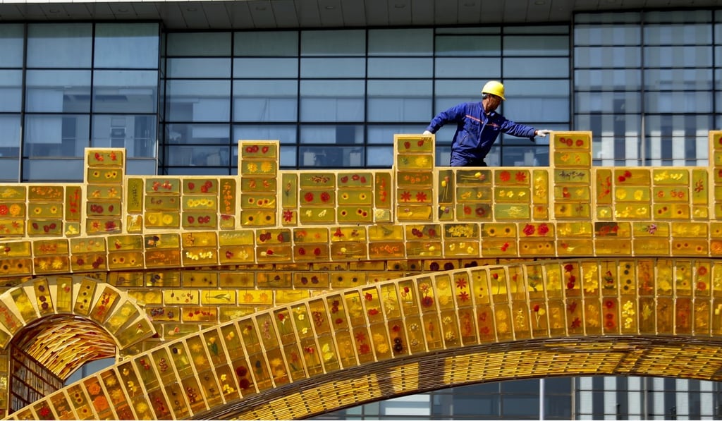 A worker walks on a ‘Silk Road Golden Bridge’ outside the National Convention Centre, which is hosting the Belt and Road Summit. Photo: AP Photo