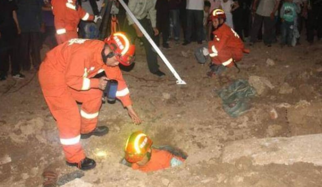 Firefighters work to rescue the mother from the hole. Photo: Handout