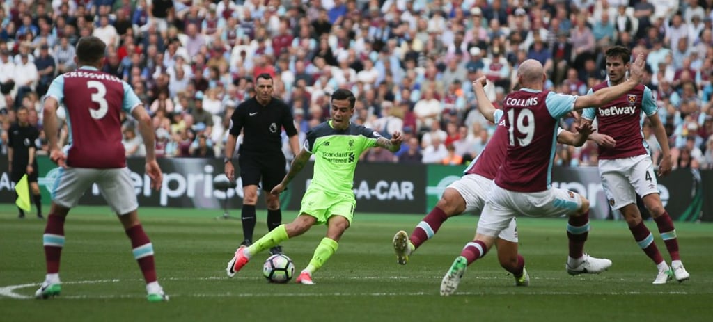 Liverpool’s Philippe Coutinho shoots past West Ham United’s James Collins to score their second goal. Photo: AFP
