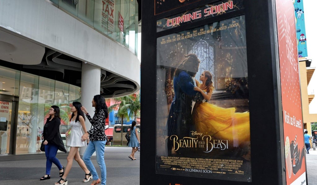 People walk past a poster for the film ‘Beauty and the Beast’ in Singapore, where Christian clergy attacked Disney for deviating from ‘wholesome, mainstream values’ regarding what they said was a gay scene. Photo: AFP