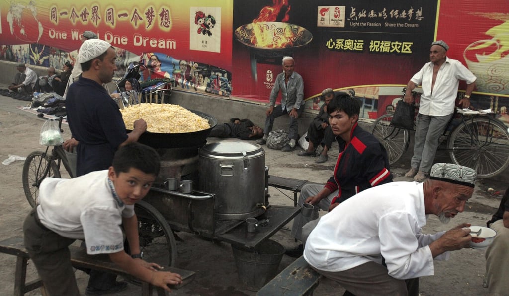 Ethnic Uygurs at a food stall in Kashgar in Xinjiang in 2008. Billboards for the Beijing Olympics can be seen in the background. Photo: AP Ethnic Uygurs at a food stall in Kashgar in Xinjiang in 2008. Billboards for the Beijing Olympics can be seen in the background. Photo: AP