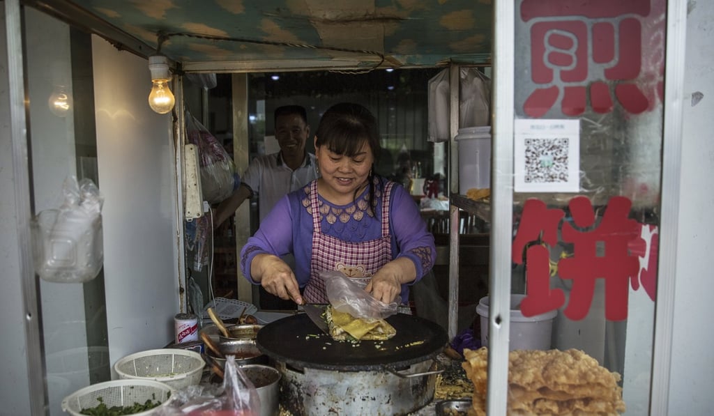 A Chinese woman cooks street food in Hutong neighbourhood in Beijing, China. Photo: EPA