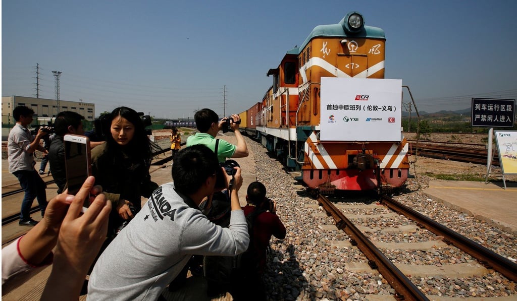 People take pictures as a train carrying containers from London arrives in Yiwu, Zhejiang province, on April 29. The sign at the front of the train reads: “First Sino-Euro Freight Train (London-Yiwu)”. Photo: Reuters