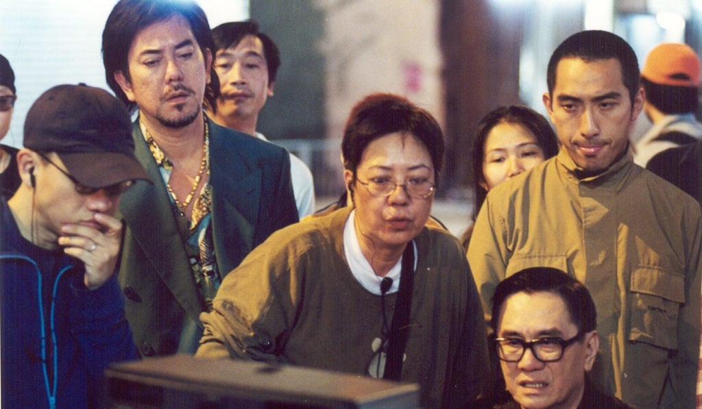 Director Ann Hui (centre) watches the day’s rushes with actors James Wong (seated) and Anthony Wong (behind Hui) as well as crew members on the set of Visible Secret (2001).