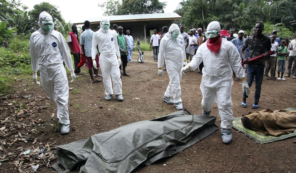 Liberian nurses prepare to carry the body of an Ebola victim for burial in Monrovia, Liberia. Photo: EPA