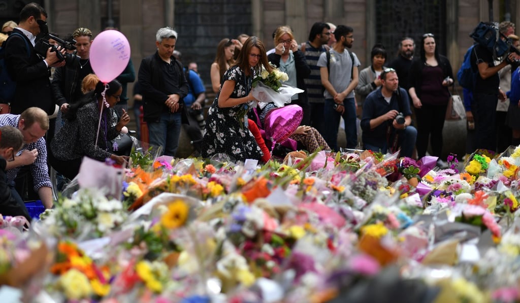 People lay flowers in St Ann's Square to pay tribute to those killed in the attack. Photo: AFP