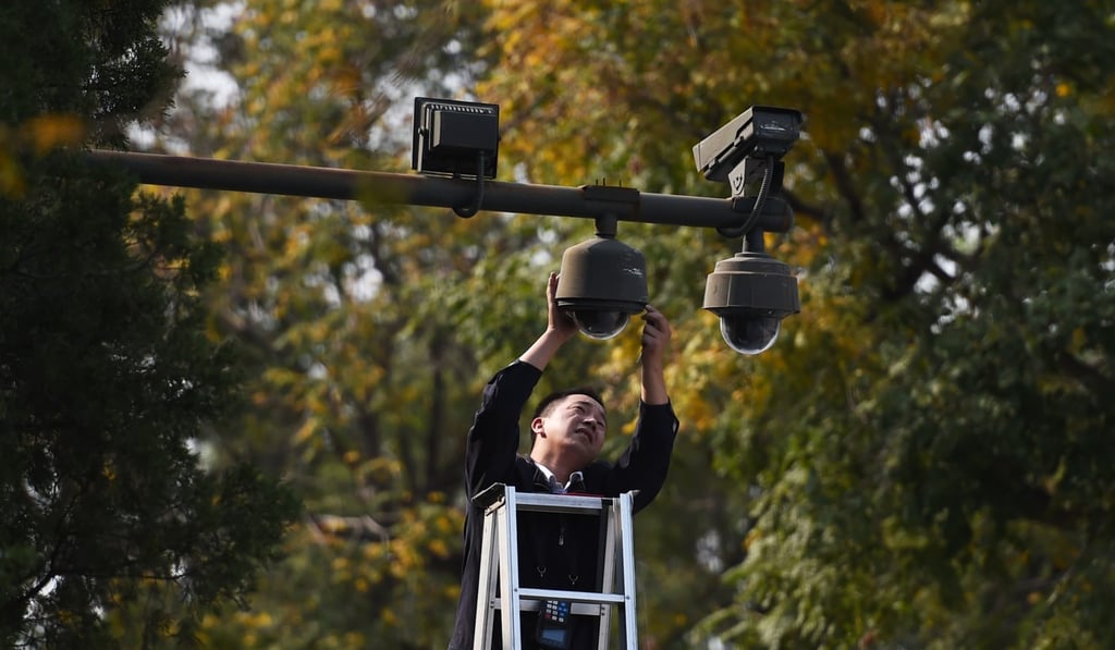 A worker adjusts security cameras on the edge of Tiananmen Square in Beijing. Photo: AFP A worker adjusts security cameras on the edge of Tiananmen Square in Beijing. Photo: AFP