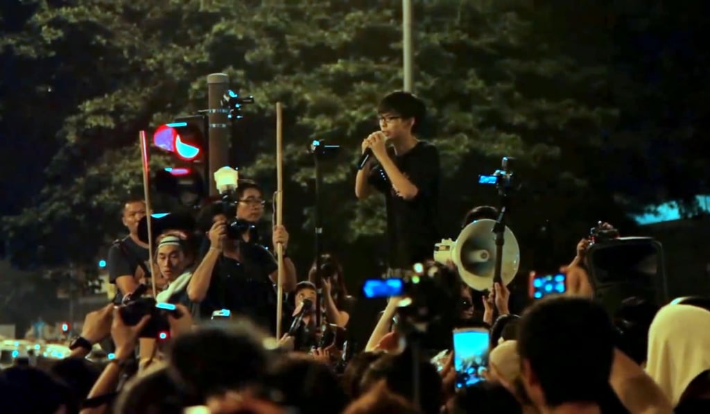 Wong addresses protesters in a still from Joshua: Teenager vs. Superpower. Wong addresses protesters in a still from Joshua: Teenager vs. Superpower.