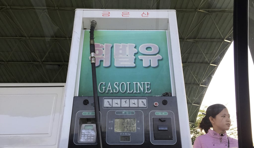 A petrol station attendant waits by a pump. Photo: AP