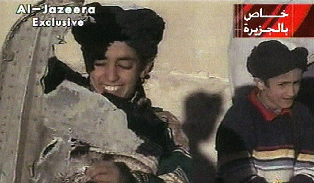 Aa young boy, left, identified as Hamza bin Laden holds what appears to be a piece of US helicopter wreckage in Ghazni, Afghanistan in 2001. File photo: AP