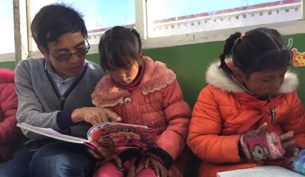 Qimei Ciren reads with some of his pupils. Photo: Handout