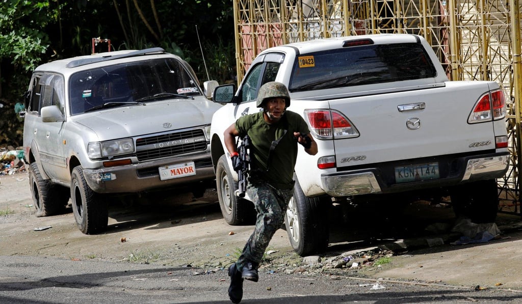 A Philippine soldier runs for cover near Maute group’s stronghold in Marawi City. Photo: Reuters
