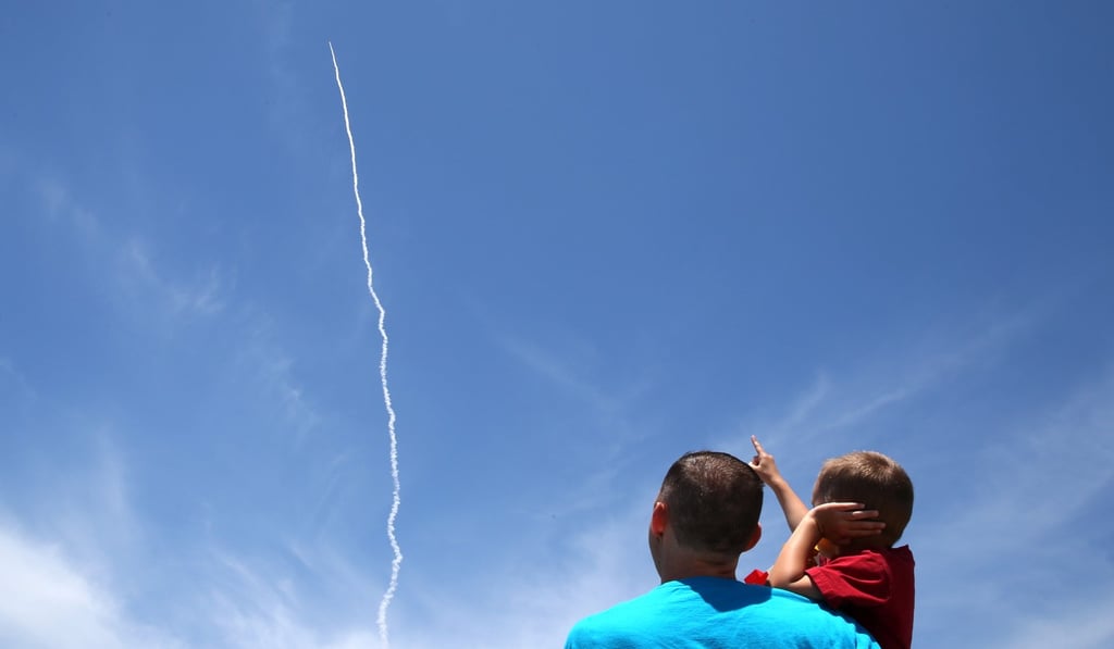 A man and a child watch as the Ground-based Midcourse Defence (GMD) element of the US ballistic missile defence system launches during a flight test from Vandenberg Air Force Base, California. Photo: Reuters