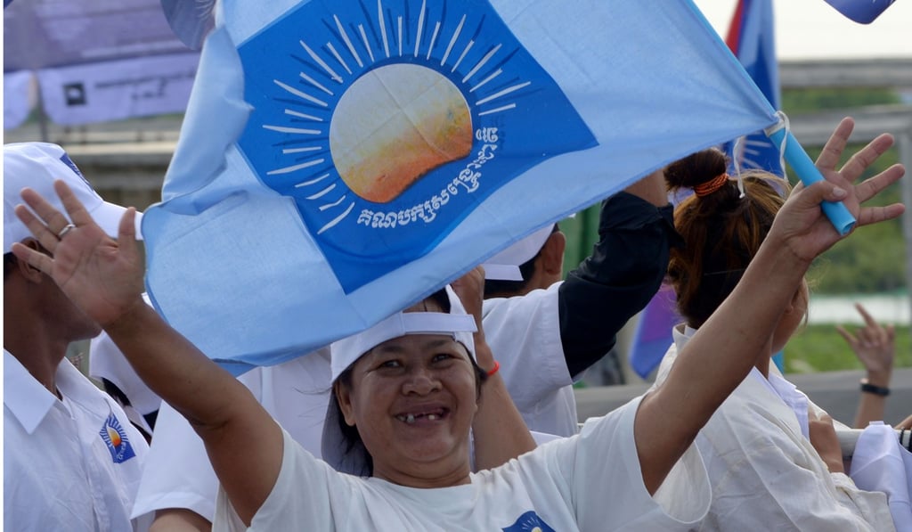 A supporter of Cambodia National Rescue Party with a party flag during a commune election rally in Phnom Penh. Photo: AFP