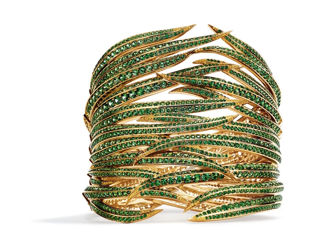 The cuff set with round tsavorites and yellow sapphires in 18ct yellow gold demonstrates the movement of leaves and adds a tropical vibe to any simple gown. Price on request