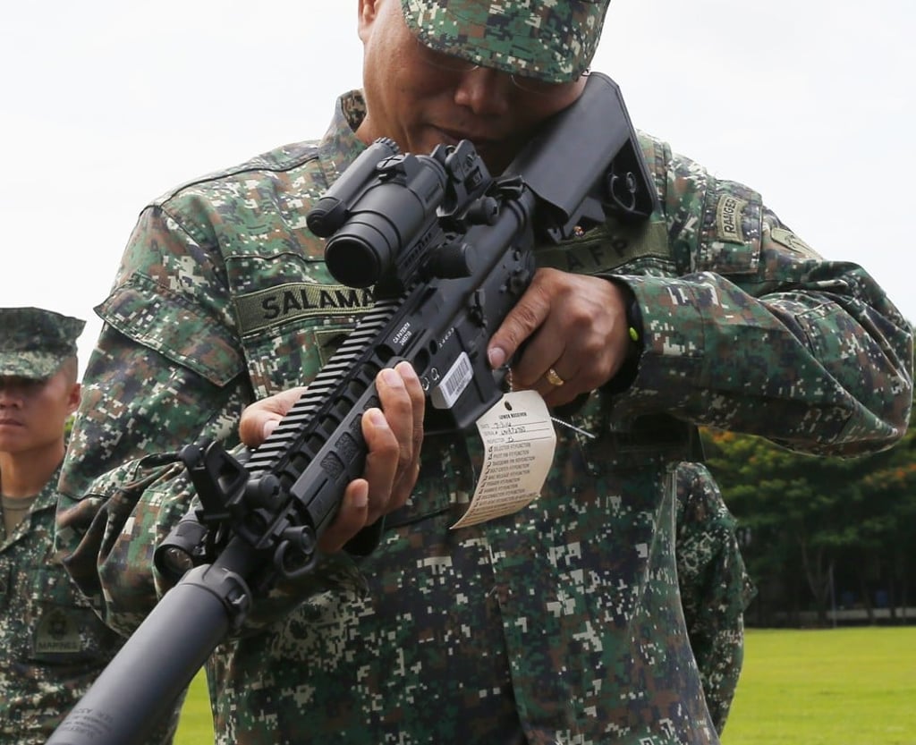 Philippine Marine Major General Emmanuel Salamat, commandant of the Philippine Marine Corps, inspects an M4 carbine. Photo: AP