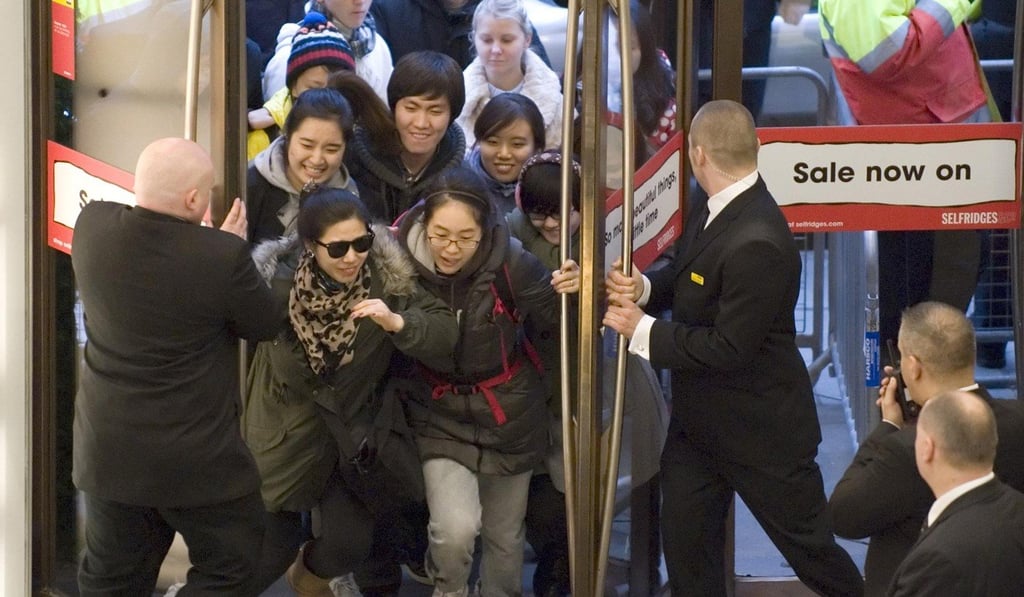 Asian tourists rush into Selfridges in central London, as the department store opens its doors for a Boxing Day sale. Photo: Press Association