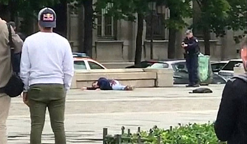 A still image taken from video shows an armed policeman standing over a wounded attacker after a shooting incident near Notre Dame catherdral in Paris on Tuesday. Photo:Reuters