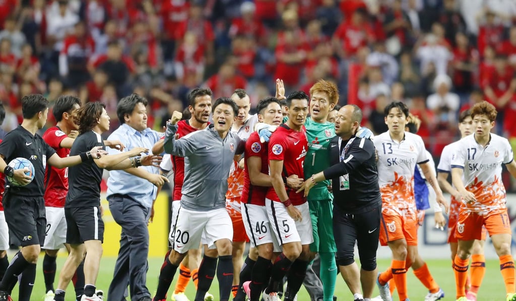 Players of South Korea’s Jeju United go after Tomoaki Makino, defender of Japan’s Urawa Reds after Urawa's 3-0 extra-time victory in the second leg of their Asian Champions League round of 16 tie in Saitama, Japan. Photo: Kyodo