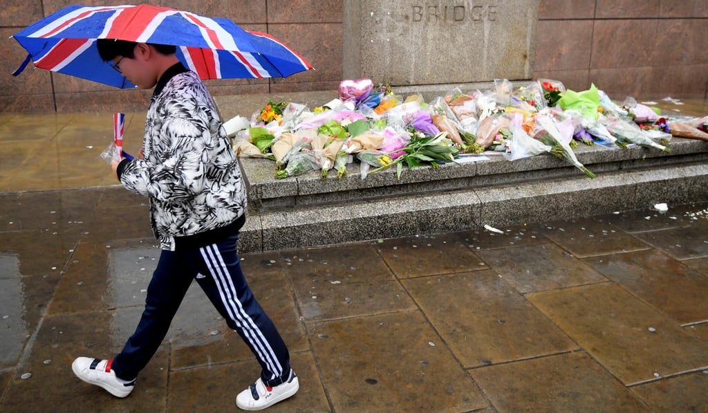 A pedestrian passes floral tributes to the victims of the recent attack at London Bridge and Borough Market. Photo: Reuters