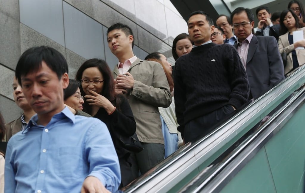 Employees finish work at the government headquarters at Tamar. Though Hong Kong only has a mandatory retirement age for the civil service, most other sectors take this as a valid reference point for their own retirement-age policies. Photo: K.Y.cheng