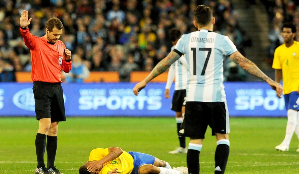 Brazil’s Gabriel Jesus (bottom) lies on the ground after suffering a broken eye socket. Photo: EPA