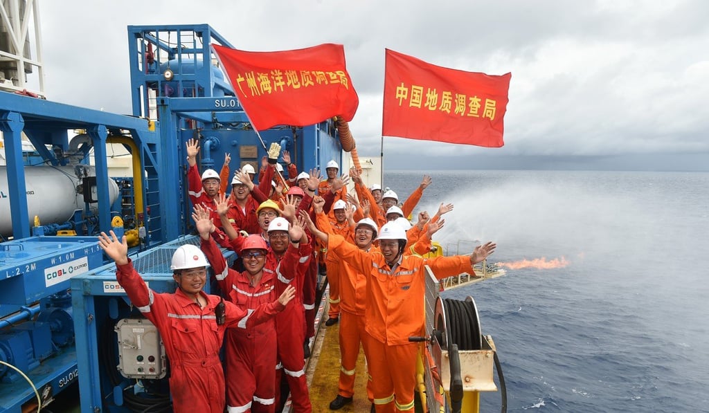 Workers celebrating the successful extraction of gas at the rig . Photo: Xinhua
