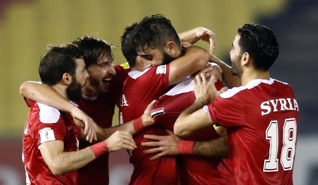Syrian players hug each other in joy after scoring an equaliser in injury time to snatch a 2-2 draw with China. Photo: Reuters