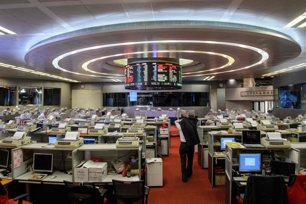 A trader puts on his jacket as he leaves the floor of the stock exchange for lunch. Photo: AFP PHOTO