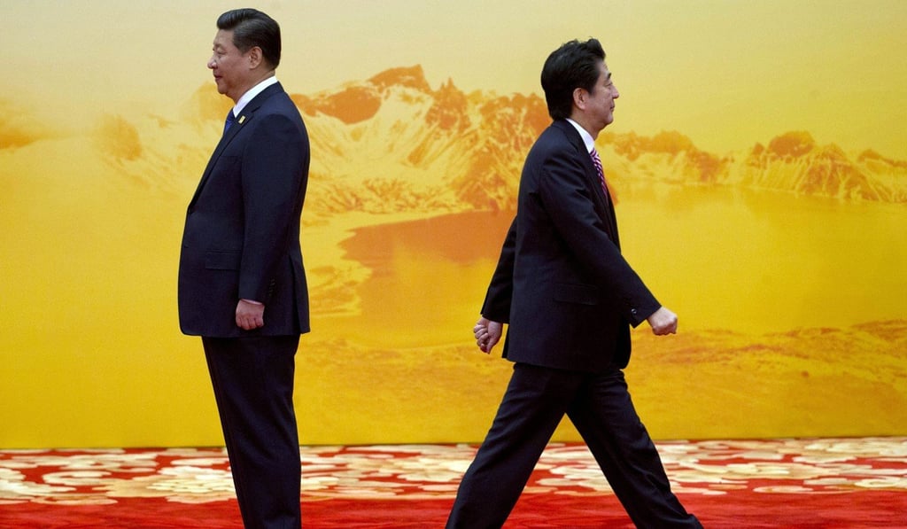 President Xi Jinping waits to welcome the next leader as Japan’s Prime Minister Shinzo Abe walks away at an Apec summit in Beijing, on November 11, 2014. Photo: AP