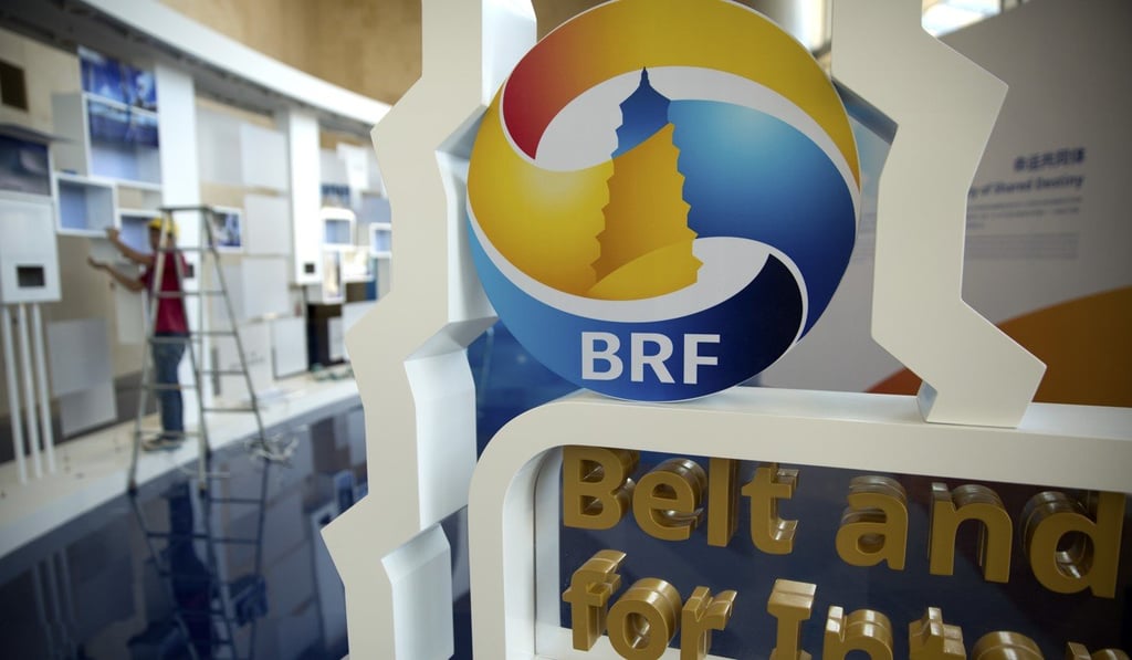 A worker disassembles a photo display for the Belt and Road Forum at the China National Convention Center in Beijing in May. Photo: AP