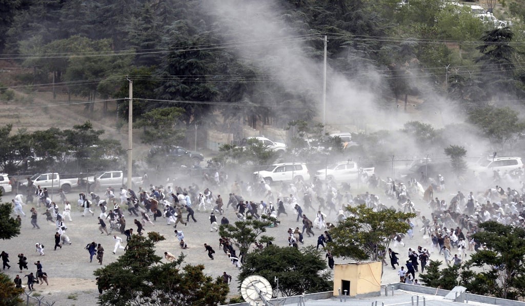 People run after an explosion during the funeral of one of the victims of violent protests in Kabul. The suicide bomb attack happened near the foreign embassies. Photo: EPA People run after an explosion during the funeral of one of the victims of violent protests in Kabul. The suicide bomb attack happened near the foreign embassies. Photo: EPA