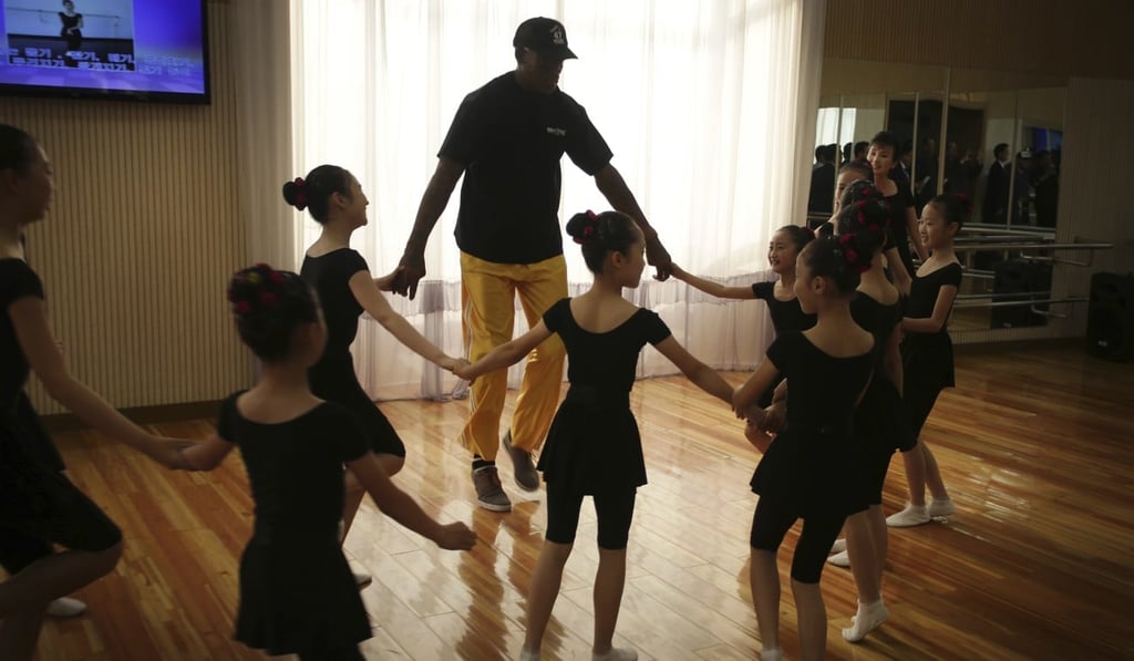 Former NBA basketball star Dennis Rodman dances with school children at the Mangyongdae School Children's Palace. Photo: AP