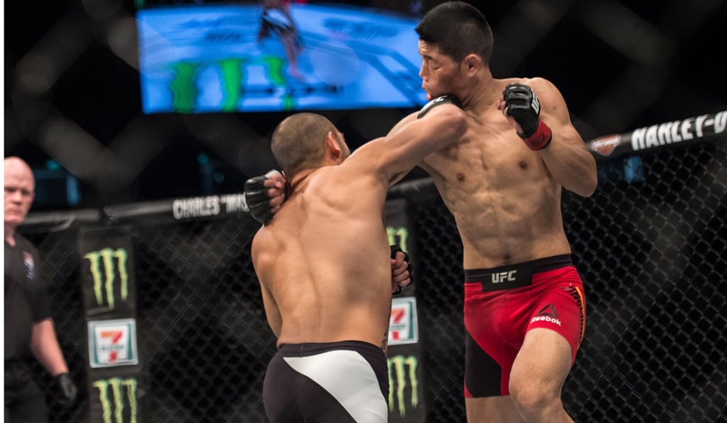 China's Li Jingliang (right) catches an elbow in the face before he dominated Saipan’s Frank Camacho. Photo: David Ash (SingaporeMaven)