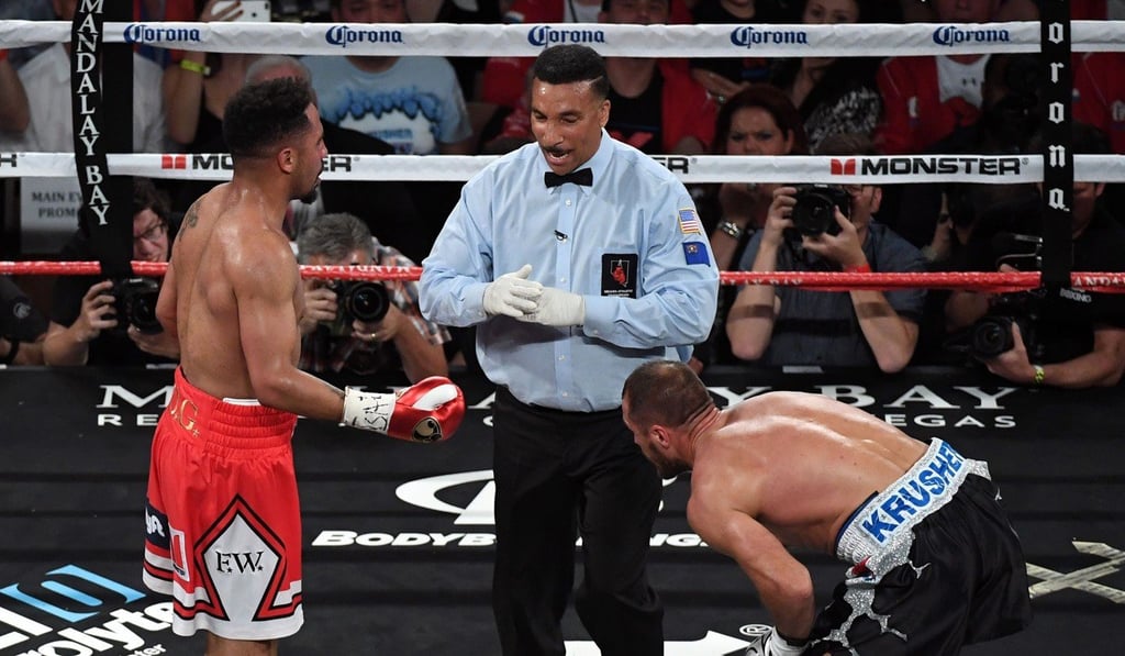 Referee Tony Weeks (centre) calls a timeout after Andre Ward (left) apparently hit Sergey Kovalev with a low blow in the second round. Photo: AFP